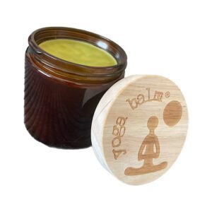 Large jar with light green balm with a lid that says "yoga balm"